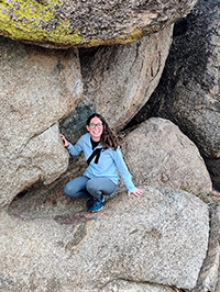 Arley Wolfand crouching on some rocks.
