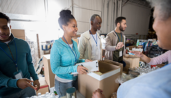 Three public health students hand out supplies to the public at a community event.