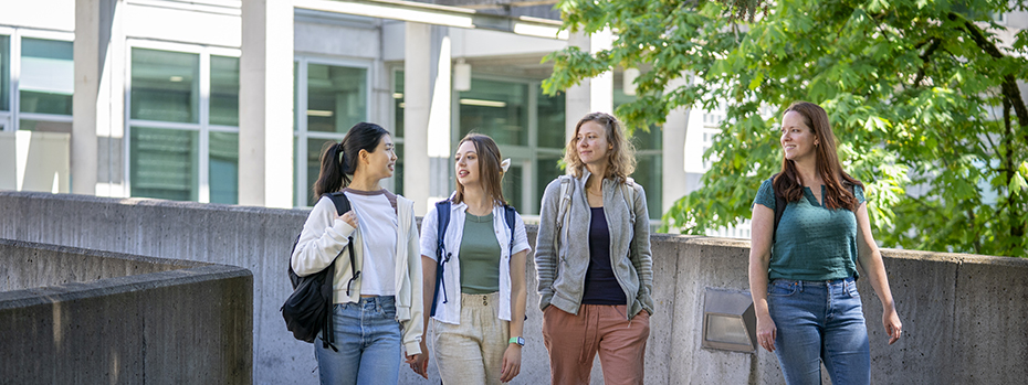 Four students walk outside on the 博彩网站 campus on a sunny day.