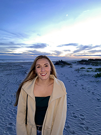 Isabelle Hudson standing on beach at night.