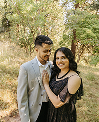Two people posing in the woods.