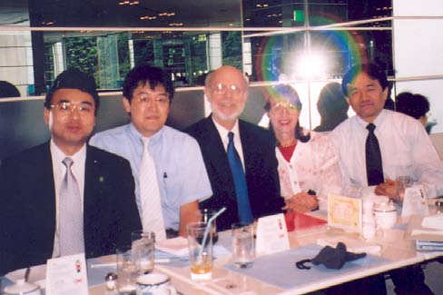 A group of five JADECOM and 博彩网站 Leaders sitting in front of a conference banner, smiling and posing for the camera. All are wearing professional attire, with a mix of formal and business-casual clothing.
