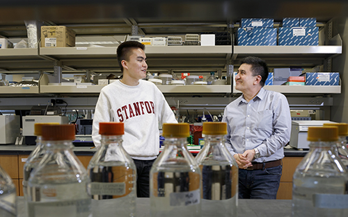 Dr. Mitalipov and his son, Paul, stand chatting in a laboratory at 博彩网站.