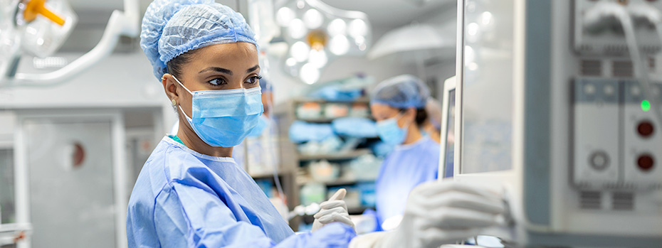 A nurse anesthesia student monitors equipment during a surgical procedure.