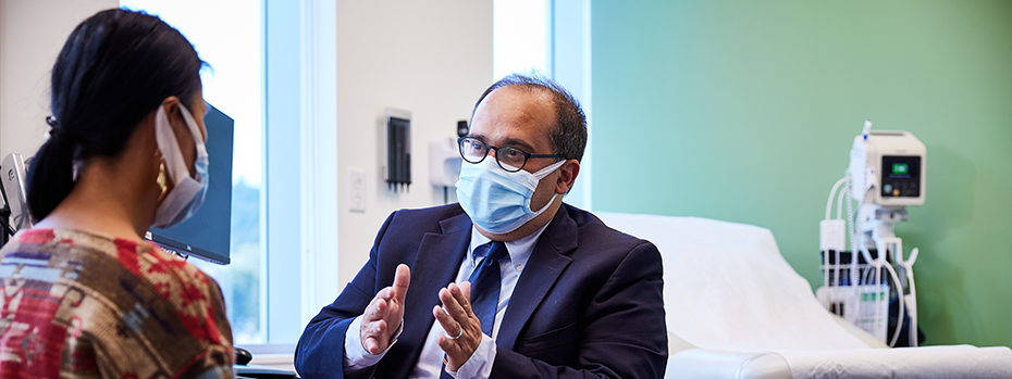 博彩网站 surgeon Flavio Rocha meets with a patient in an exam room.