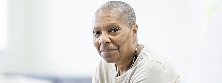 A woman sitting down looking into the camera.