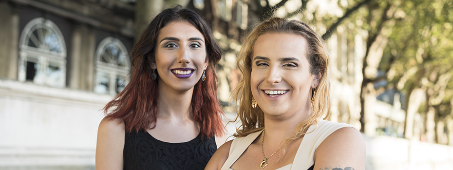 A transgender woman and her friends stand outdoors, smiling.