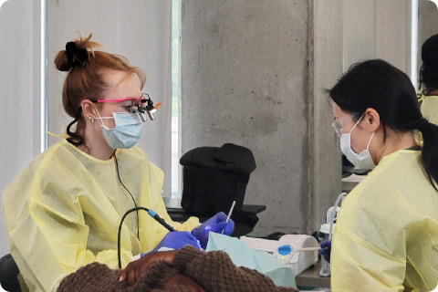 Two students work with a patient at Bridges Clinic