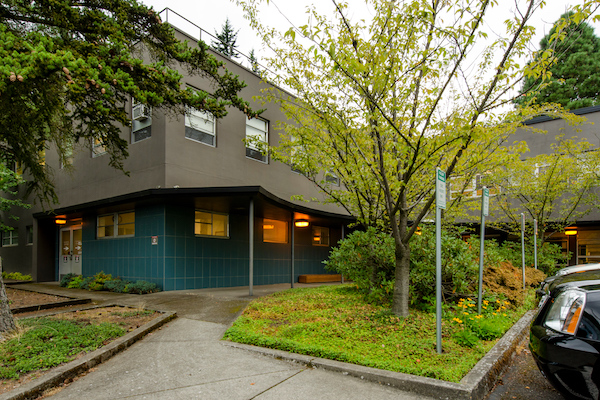 Green building with cement upper with tree in front of it Green building with cement upper with tree in front of it