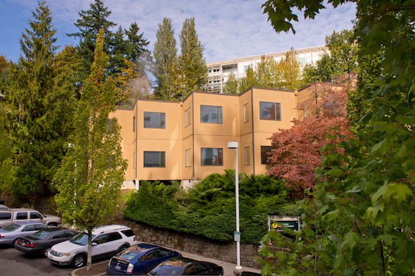 Office building behind a parking lot surrounded by trees Office building behind a parking lot surrounded by trees