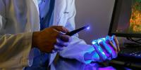 A scientist illuminates a biofabricated tissue sample with a blue light